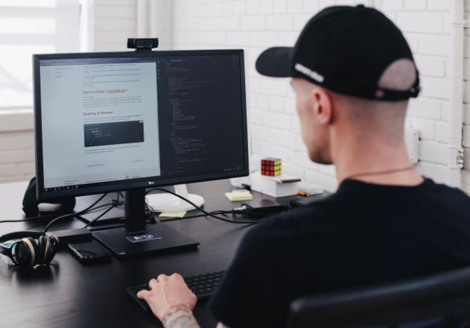 Developer in a cap working at a computer