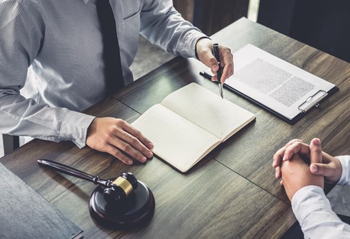 Lawyer reviewing documents with a gavel on the desk