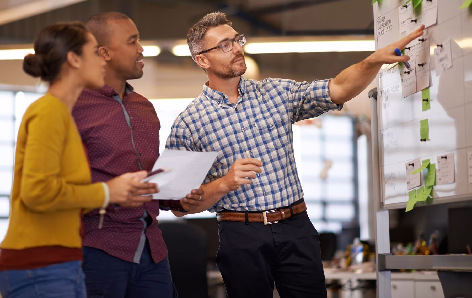 Team planning a project at a whiteboard with sticky notes